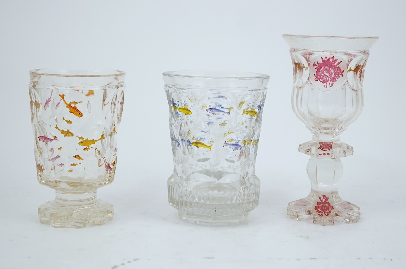 Two Bohemian transparent enamelled ‘fish’ beakers, and a similar faceted goblet, c.1840-60